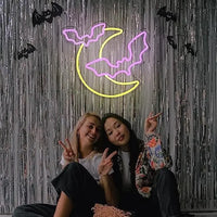 Letreros de neón con forma de murciélago y Luna.